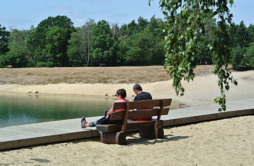 Paar ruht sich auf einer Bank am See aus