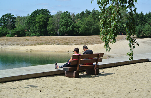 Paar sitzt auf Bank am Strand